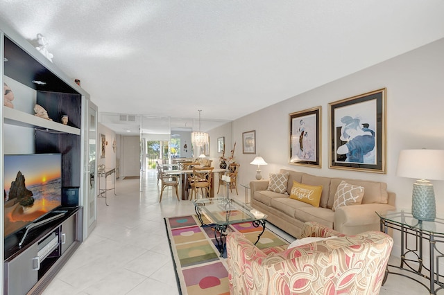 living room with light tile patterned floors and a notable chandelier