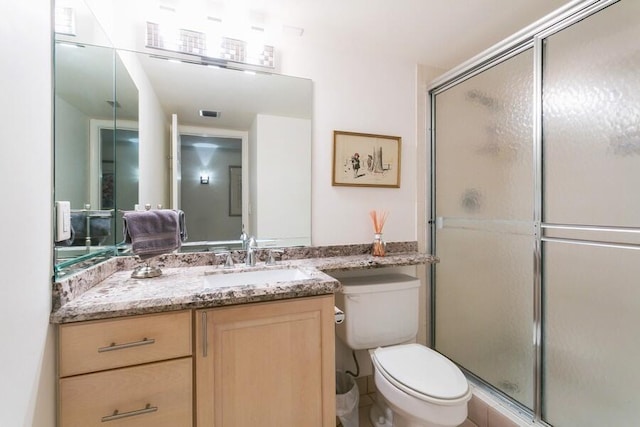 bathroom with vanity, an enclosed shower, and toilet