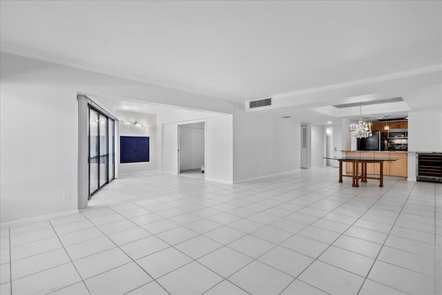 unfurnished living room with a notable chandelier, light tile patterned floors, crown molding, and beverage cooler