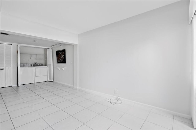 spare room featuring washing machine and clothes dryer and light tile patterned floors