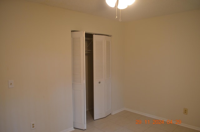 unfurnished bedroom with light tile patterned flooring and a closet