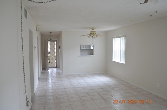 tiled empty room with a textured ceiling and ceiling fan