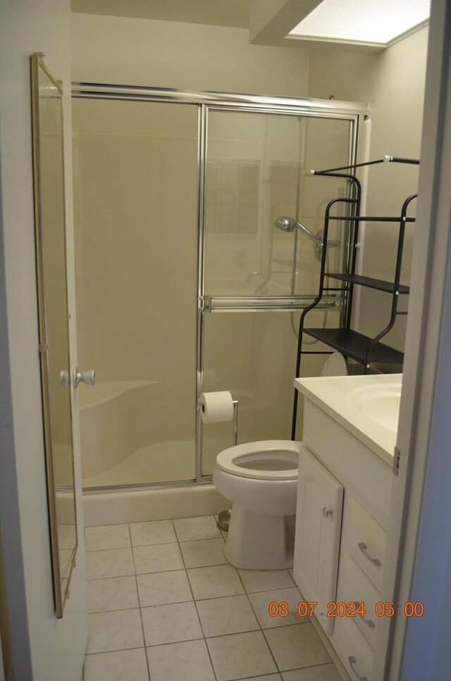 bathroom with a shower with door, toilet, and vanity