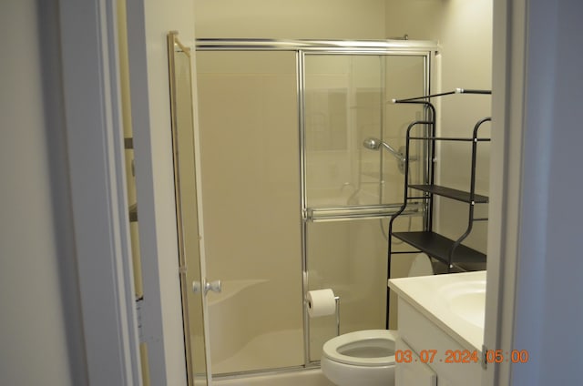 bathroom with toilet, vanity, and walk in shower