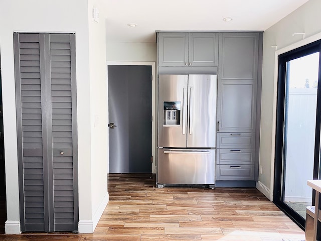 kitchen featuring gray cabinetry, stainless steel refrigerator with ice dispenser, and light hardwood / wood-style flooring