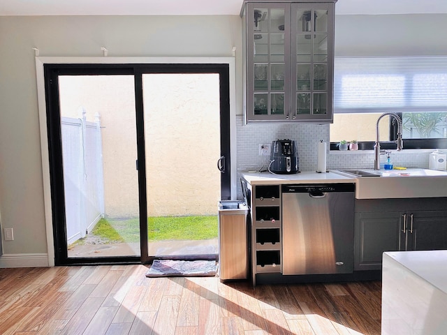 kitchen with gray cabinets, a wealth of natural light, dishwasher, and sink