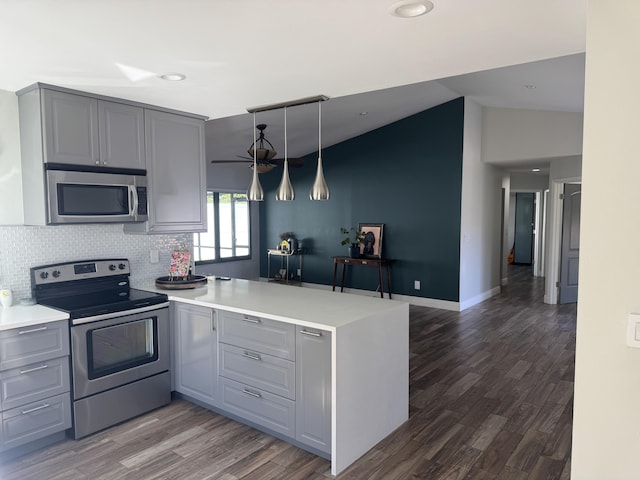 kitchen with kitchen peninsula, decorative backsplash, stainless steel appliances, gray cabinets, and hanging light fixtures