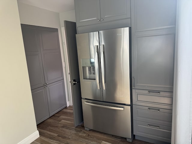 kitchen with gray cabinetry, stainless steel fridge, and dark wood-type flooring