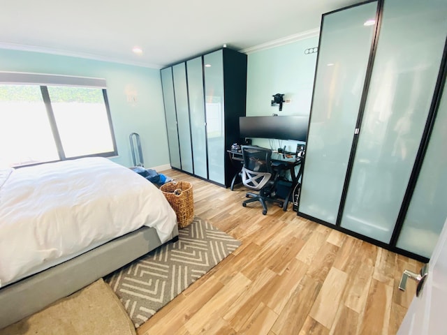 bedroom with light hardwood / wood-style floors and crown molding