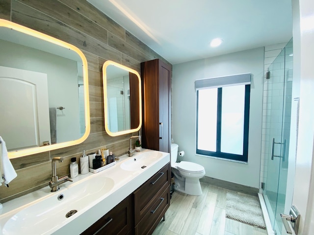 bathroom with toilet, decorative backsplash, vanity, a shower with shower door, and hardwood / wood-style flooring