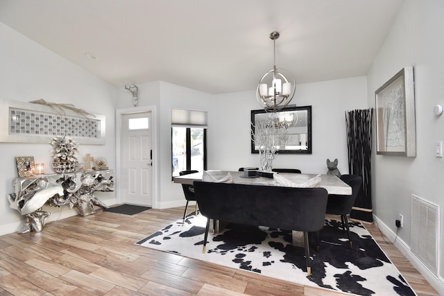 dining room with vaulted ceiling and a chandelier