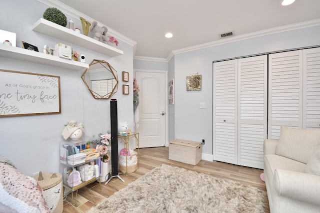 sitting room with light hardwood / wood-style flooring and ornamental molding