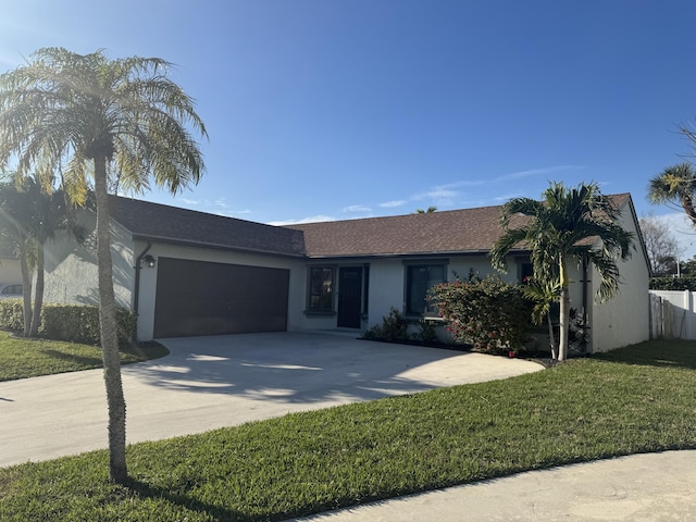 ranch-style house with a garage and a front lawn