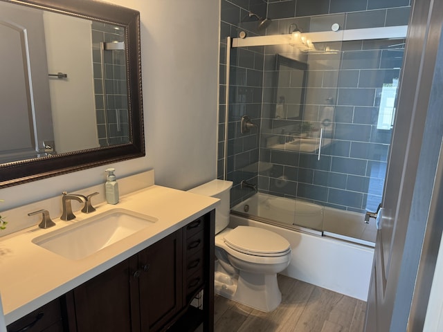 full bathroom with vanity, toilet, and enclosed tub / shower combo