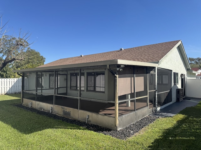 back of house featuring a sunroom and a yard