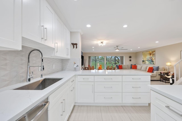 kitchen with backsplash, white cabinetry, and sink