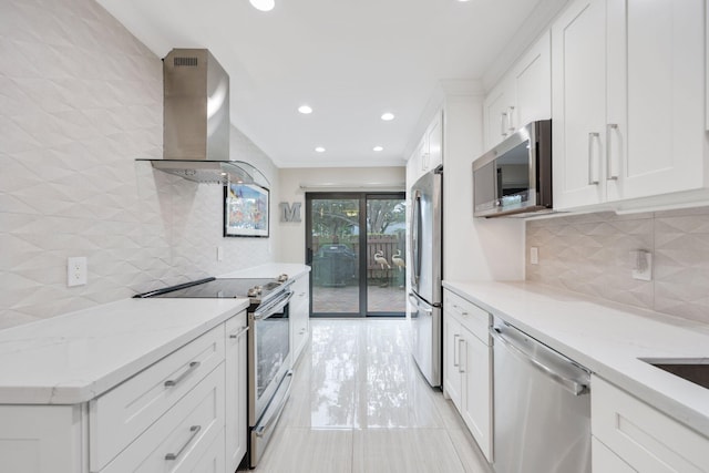 kitchen featuring white cabinets, wall chimney range hood, light stone countertops, appliances with stainless steel finishes, and light tile patterned flooring