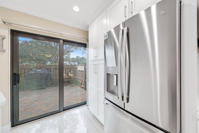 kitchen featuring white cabinets, stainless steel fridge with ice dispenser, ornamental molding, and light tile patterned flooring