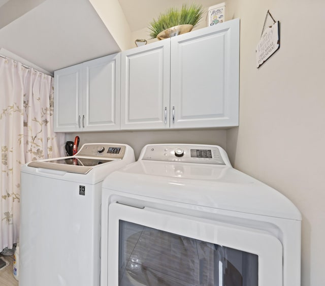 washroom featuring washer and dryer and cabinets