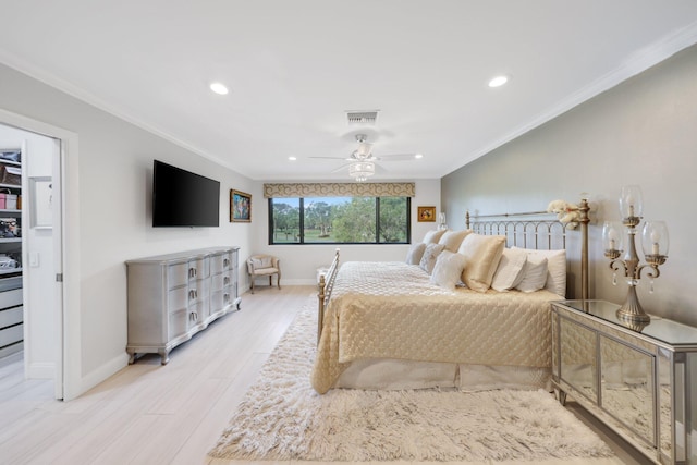 bedroom with a walk in closet, light hardwood / wood-style flooring, ceiling fan, and crown molding