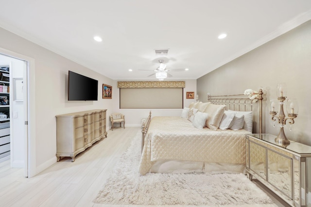 bedroom featuring hardwood / wood-style flooring, a spacious closet, ceiling fan, and ornamental molding