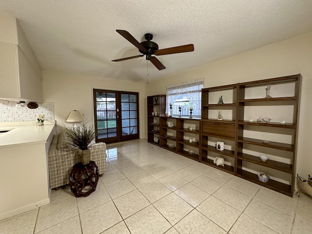 living area featuring ceiling fan, plenty of natural light, a textured ceiling, and french doors