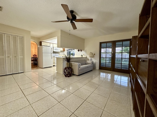 unfurnished living room with light tile patterned floors, french doors, a textured ceiling, and ceiling fan