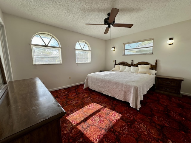 carpeted bedroom featuring ceiling fan and a textured ceiling