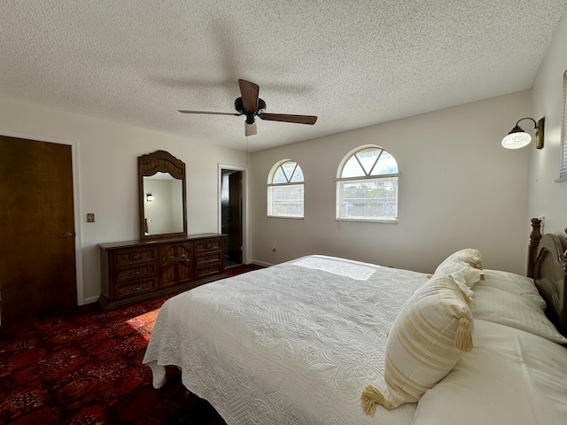 bedroom with ceiling fan and a textured ceiling