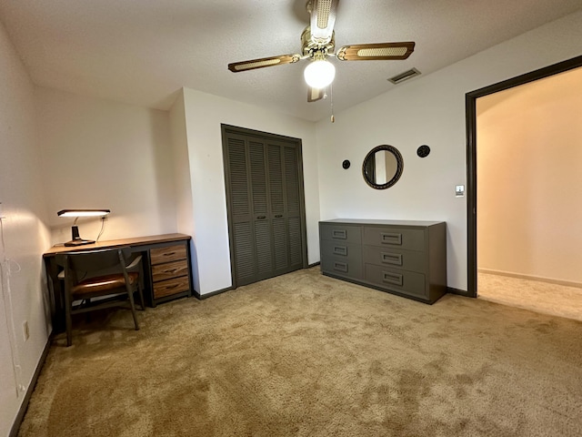 carpeted bedroom featuring ceiling fan and a closet