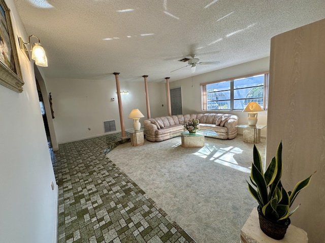 living room featuring ceiling fan and a textured ceiling