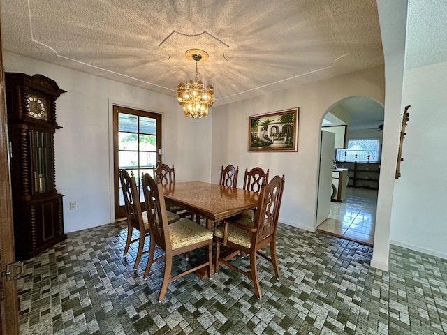 dining space featuring a textured ceiling and an inviting chandelier