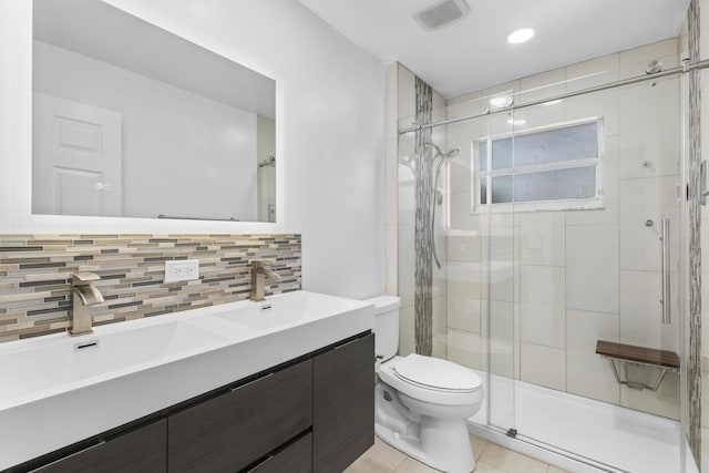 bathroom with vanity, backsplash, tile patterned floors, toilet, and walk in shower