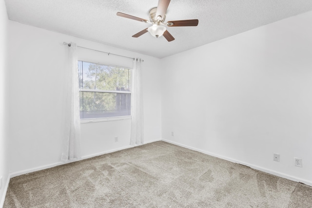 unfurnished room with ceiling fan, light carpet, and a textured ceiling