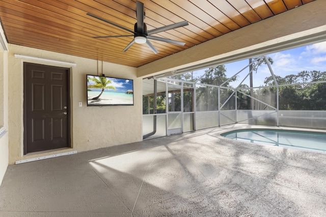 view of swimming pool featuring a patio, glass enclosure, and ceiling fan