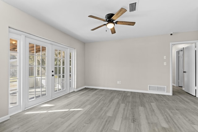 empty room featuring french doors, light wood-type flooring, and ceiling fan