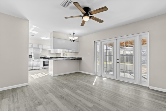 kitchen with french doors, hanging light fixtures, kitchen peninsula, white cabinets, and appliances with stainless steel finishes