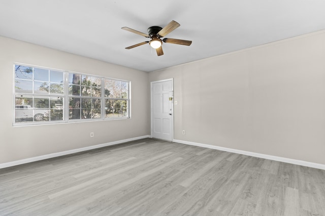 empty room with ceiling fan and light hardwood / wood-style floors