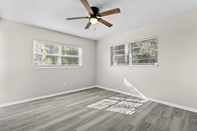 empty room with ceiling fan and light hardwood / wood-style floors