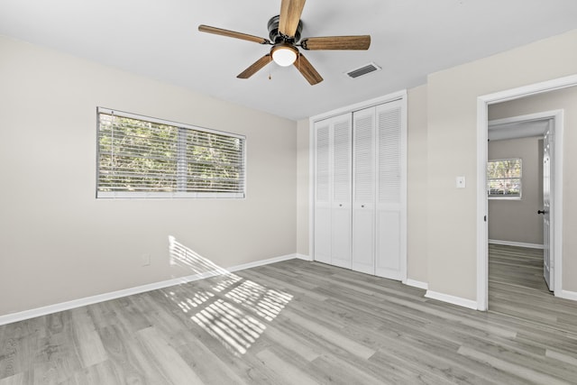 unfurnished bedroom featuring ceiling fan, a closet, and light hardwood / wood-style floors