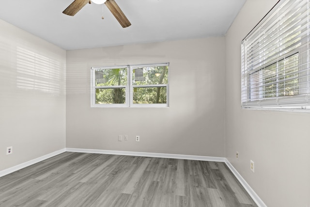 spare room with plenty of natural light, ceiling fan, and light hardwood / wood-style floors