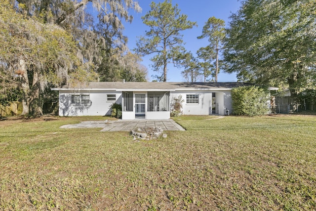 back of property with a yard, a patio area, and a sunroom