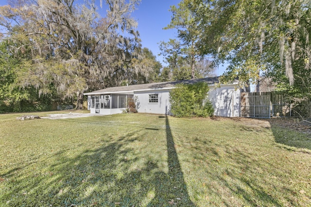 3331 NW 27th Ave, Gainesville, FL 32605 - rear view of house with fence, a sunroom, a lawn, and stucco siding