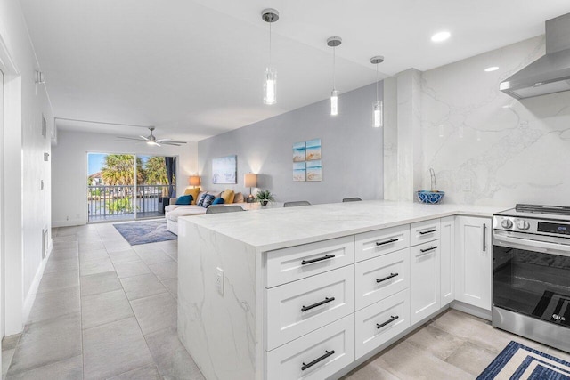 kitchen with white cabinets, decorative light fixtures, wall chimney exhaust hood, and stainless steel range oven