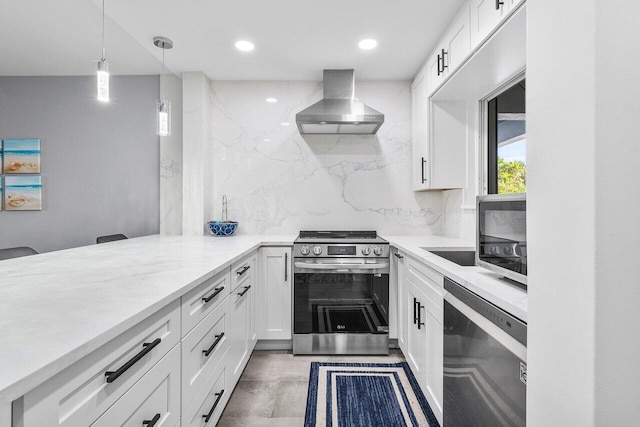 kitchen featuring white cabinets, hanging light fixtures, electric range, wall chimney exhaust hood, and light stone countertops