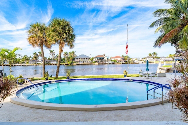 view of pool with a patio and a water view