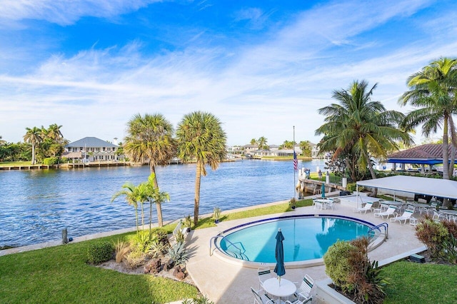 view of pool with a patio area and a water view