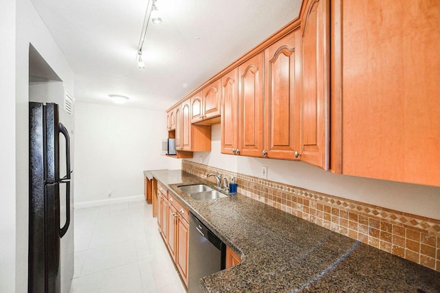 kitchen with backsplash, stainless steel dishwasher, sink, track lighting, and black refrigerator