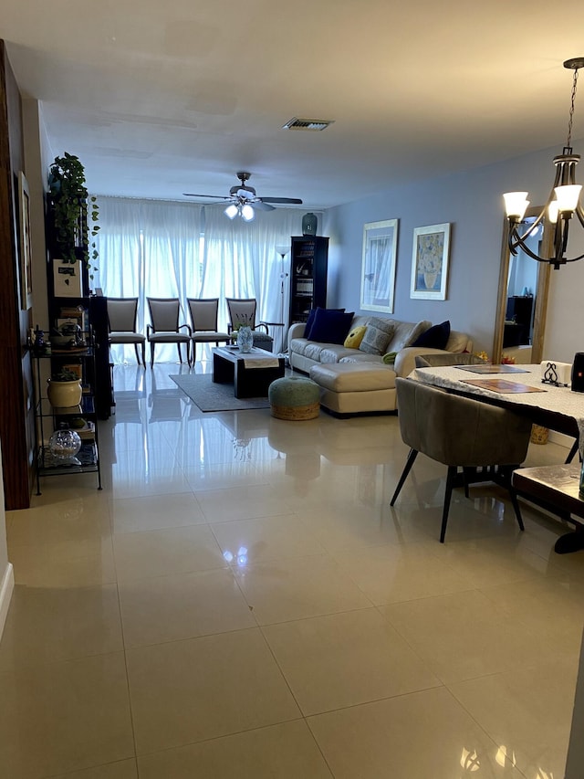 living room with tile patterned flooring and ceiling fan with notable chandelier