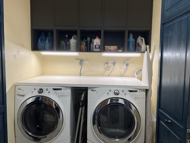 laundry area with cabinets and washing machine and clothes dryer